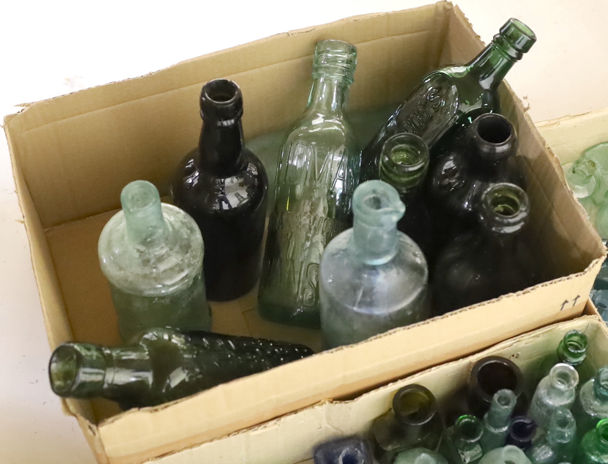 A collection of late 19th/early 20th century glass ink bottles, drink bottles and sauce bottles, brand names and advertising moulded into the glass on a number of examples, many ink bottles with pen rests moulded into th